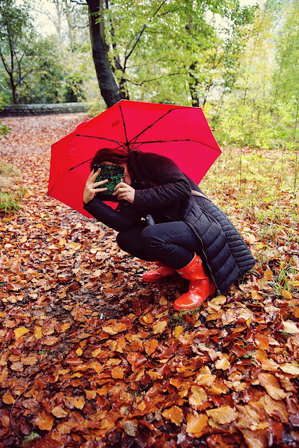 woman crouching taking photo in woods