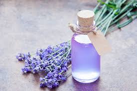 Lavender oil bottle and some lavender flowers