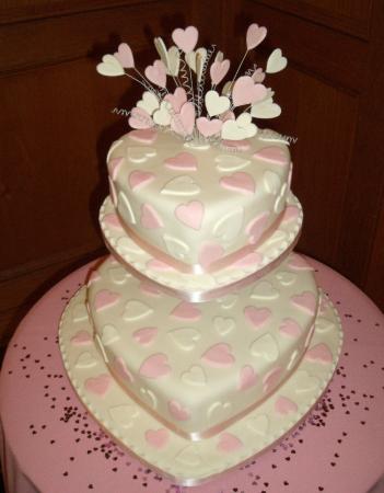 White and pink two tier wedding cake with heart pattern and heart cake 