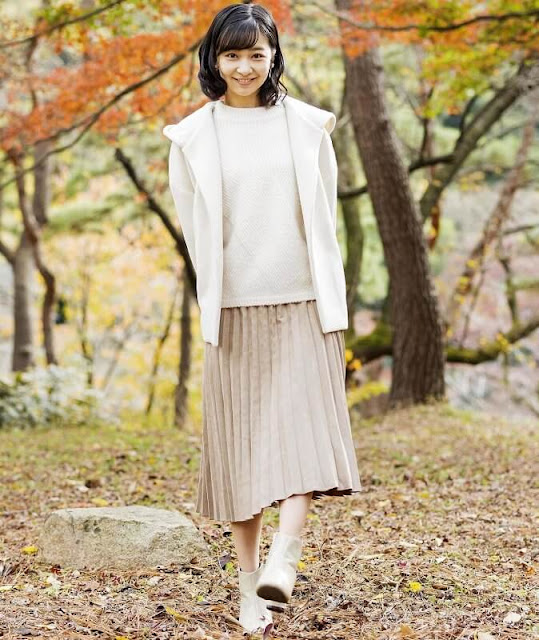 Princess Kako wore a white jumper and a white cashmere hoodie jacket with a cream pleated skirt
