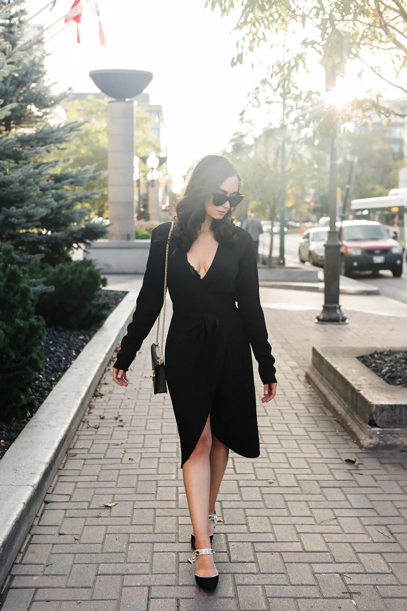 woman in a stylish total black look wearing wrap dress