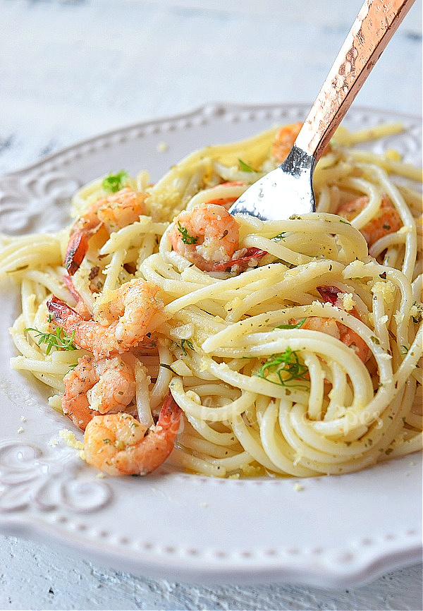 a plate with classic shrimp scampi topped with parmesan and chopped parsley