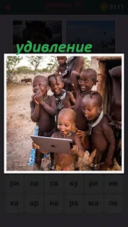 чернокожие дети смотрят в планшет и удивляются