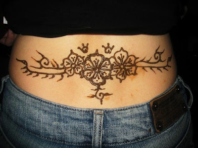 Three flowers henna tattoo on a female's lower back.
