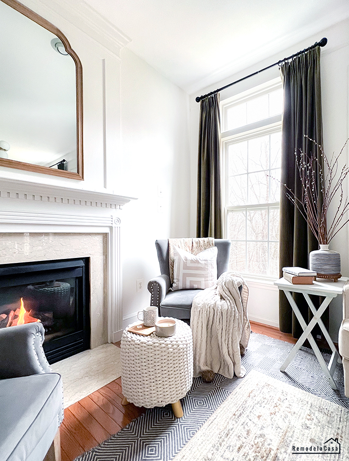 Family room with velvet curtains, mirror and fireplace