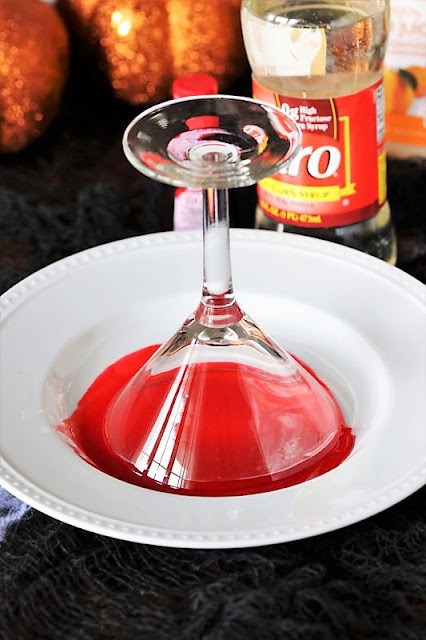 Dipping Rim of Glass in Corn Syrup Blood to Make Bloody Sunrise Halloween Cocktail Image