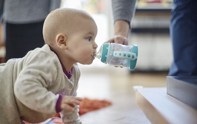 climbing baby is fed water