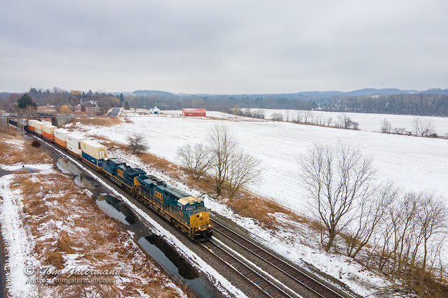 CSX intermodal train I017-02 is westbound, passing under the Oakland Rd. bridge and by snow-covered fields.