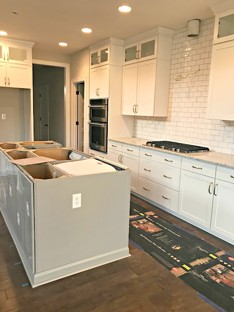 gray island white cabinets brass hardware