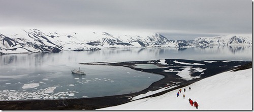 Tourists hiking down the mountainside towards Whalers Bay, Deception Island, South Shetland Islands, Antarctic Peninsula, Antarctica