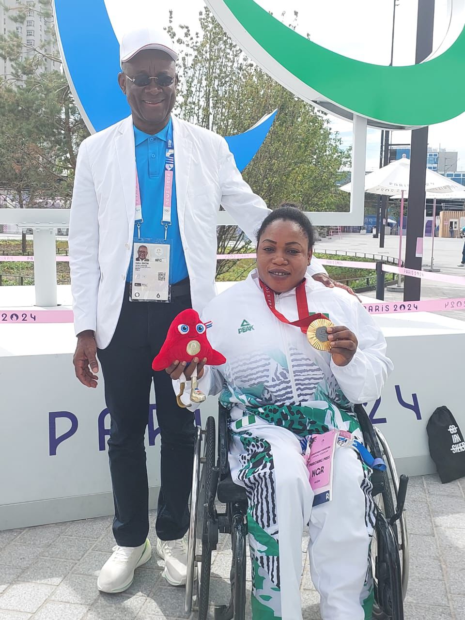 Senator John Owan Enoh, Minister of Sports Development, takes a shot with Nigeria's Powerlifter, Oyinyechi Mark, after winning Gold at the Paralympic Games Paris 2024