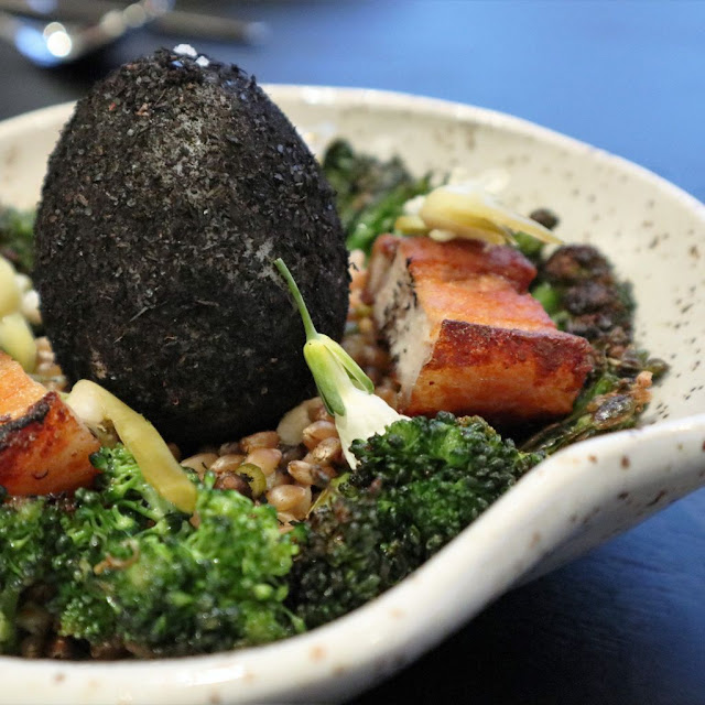 Ash covered duck egg on a bed of lentils, broccoli and pork belly