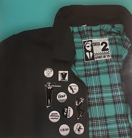 A harrington jacket is covered with badges for The Specials, The Beat, The Selecter, and other 2 Tone bands.