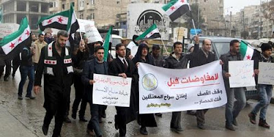 Residents carry banners and opposition flags as they march during a protest in Aleppo