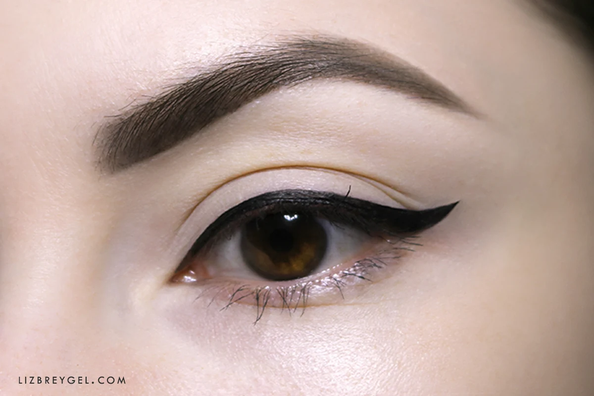 a close-up of an opened woman's eye with a pin-up eyeliner look