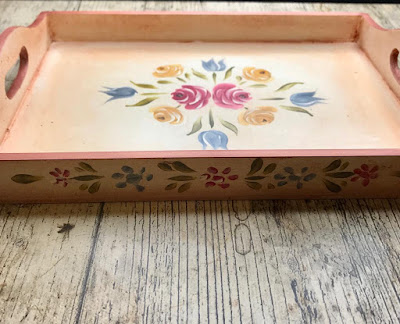 A photo of the sides of the tea tray decorated with hand painted daisies and leaves in the Bauernmalerai style 