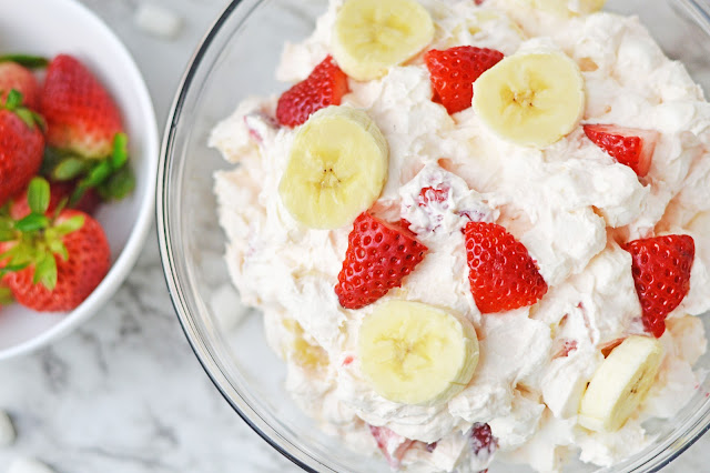 close up of Strawberry Banana Cheesecake Fluff Salad in a clear glass bowl.