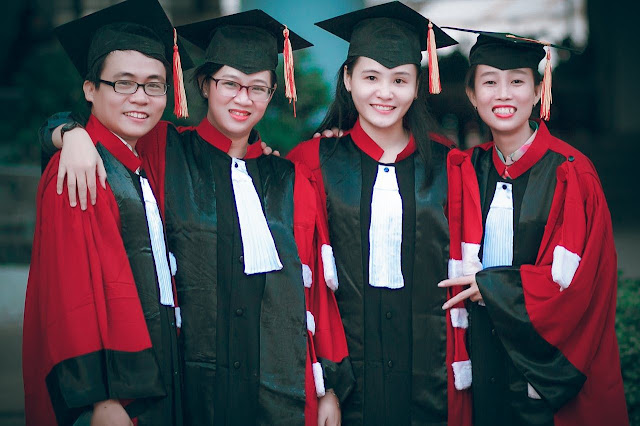 A group picture of one boy and three girls in cap and gown