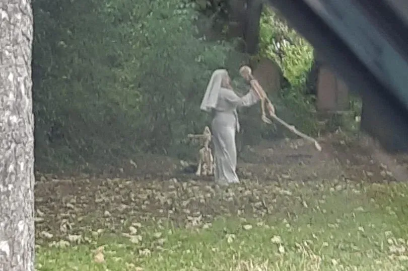 Woman dressed as nun seen dancing with skeletons in graveyard