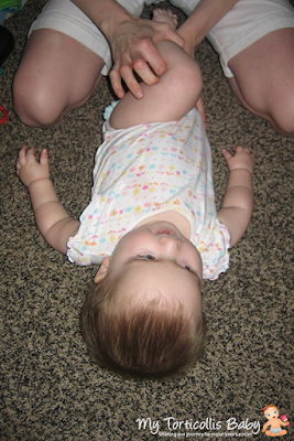 Baby with torticollis laying on floor doing a physical therapy exercise