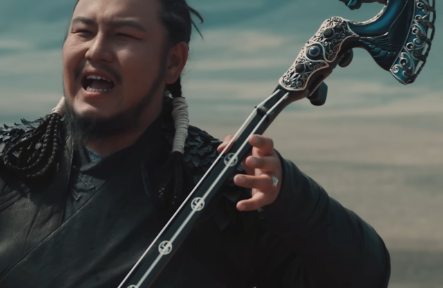 Mongolian man playing a string instrument with swastika inlays on the fingerboard.