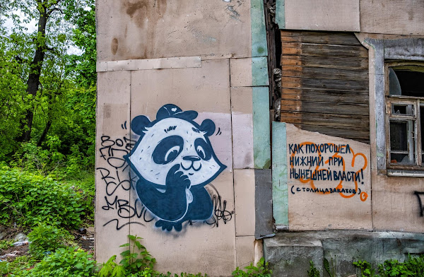 Панда на разваливающемся доме с надписью "Как Похорошел Нижний при нынешней Власти"