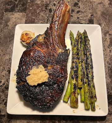Cowboy ribeye grilled Pittsburgh rare with horseradish, roasted garlic and grilled asparagus