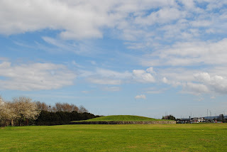 A photo showing a field and a low mound with a wall running around it (Huly Hill).  Photo by Kevin Nosferatu for the Skulferatu Project.