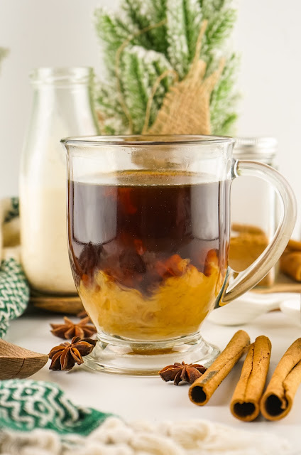 clear coffee cup with creamer before being mixed.