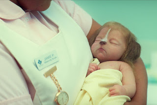 Baby human/animal hybrid held by a nurse