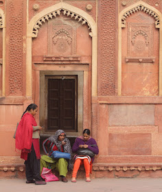 Local ladies gossip session in front of an ornate door, Red Fort, Agra, India