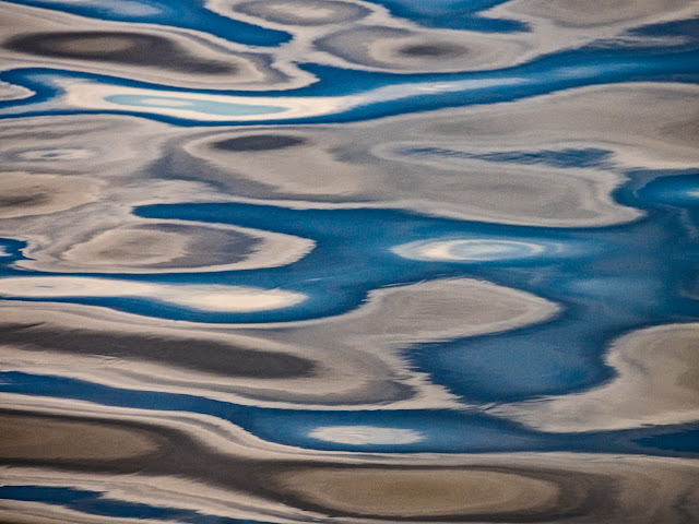 Photo of blue sky and clouds reflected in the calm surface of the Solway Firth