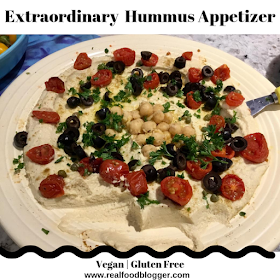 hummus appetizer with olives, roasted tomatoes, and chick peas