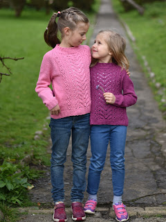 Two girls are modelling in matching knitted sweaters in different pink shades