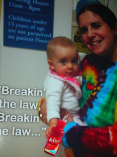 My sister holding baby Riley in front of a sign that says visitors must be 13 or older.  Below, my brother wrote a caption "Breaking the law."