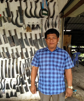 blacksmith, cambodia, battambang, standing in front of a range of handmade tools and blades