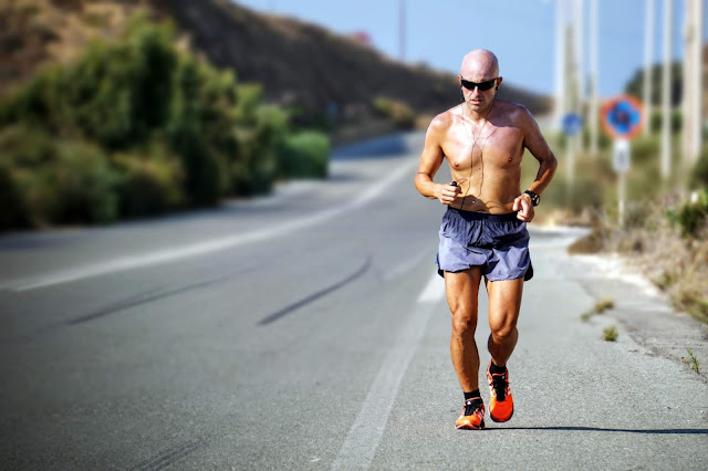 Man wearing head phones running on the road