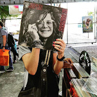 Personas se toman fotos con discos de vinilos