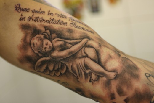 Cherub tattoos are sometimes presented as portraits with lifelike faces and