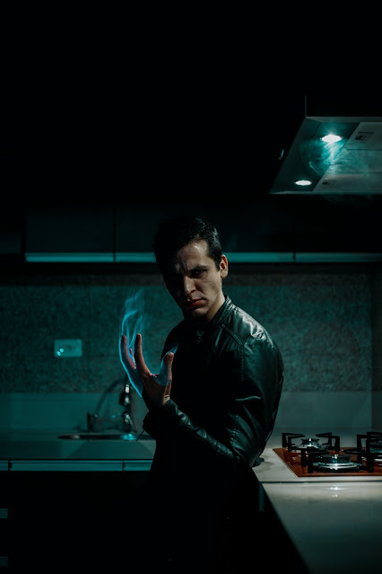 man in dark coat with. magic flame encapsulating his hand