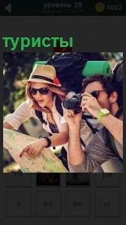 На отдыхе на экскурсии находятся туристы и фотографируют с рюкзаками за спиной и картой в руках 