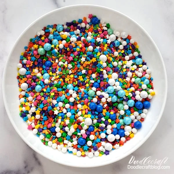 Step 2 for Designer Sprinkles Mix:  Pour all the sprinkle packages into the same bowl.    Use a spoon to stir and mix them up.