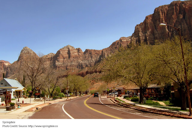 quiet town Main Street line with shops and mountains in the background