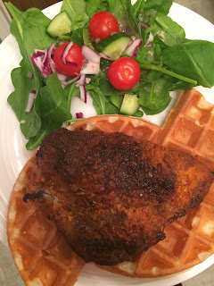 baked chicken breast on top of a waffle with a garden salad