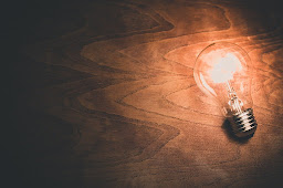 A light bulb on a dark table lighting up its surroundings