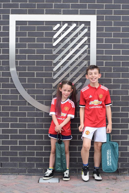 boy and girl in manchester united kit outside Hotel Football