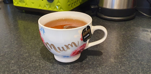 A cup of tea steeps on a countertop