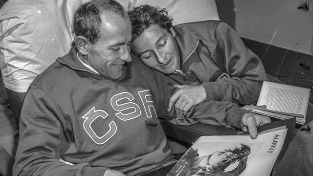 Foto em preto branco mostrando Emil Zátopek e Dana Zátopková, já idosos com agasalhos esportivos