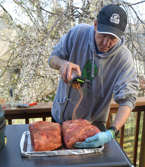 Chris Grove seasoning pork butts for the smoker