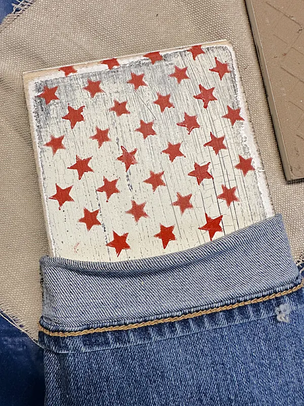 stars stenciled on a board in a blue jean pocket